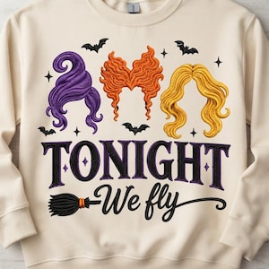Könnte beinhalten: Ein cremefarbenes Sweatshirt mit Rundhalsausschnitt und einer Stickerei von drei stilisierten Frisuren in Lila, Orange und Gelb. Unter den Haaren befinden sich schwarze Fledermäuse, Sterne und der Text "TONIGHT We fly" mit einem Besen.