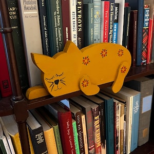 Figura de gato naranja sentada en un estante, arte popular de madera hecho a mano