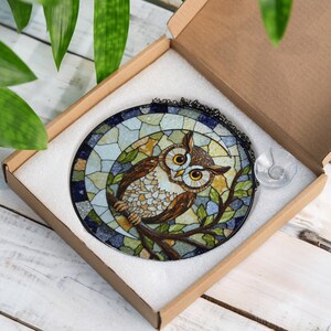 a stained glass owl sitting on a tree branch