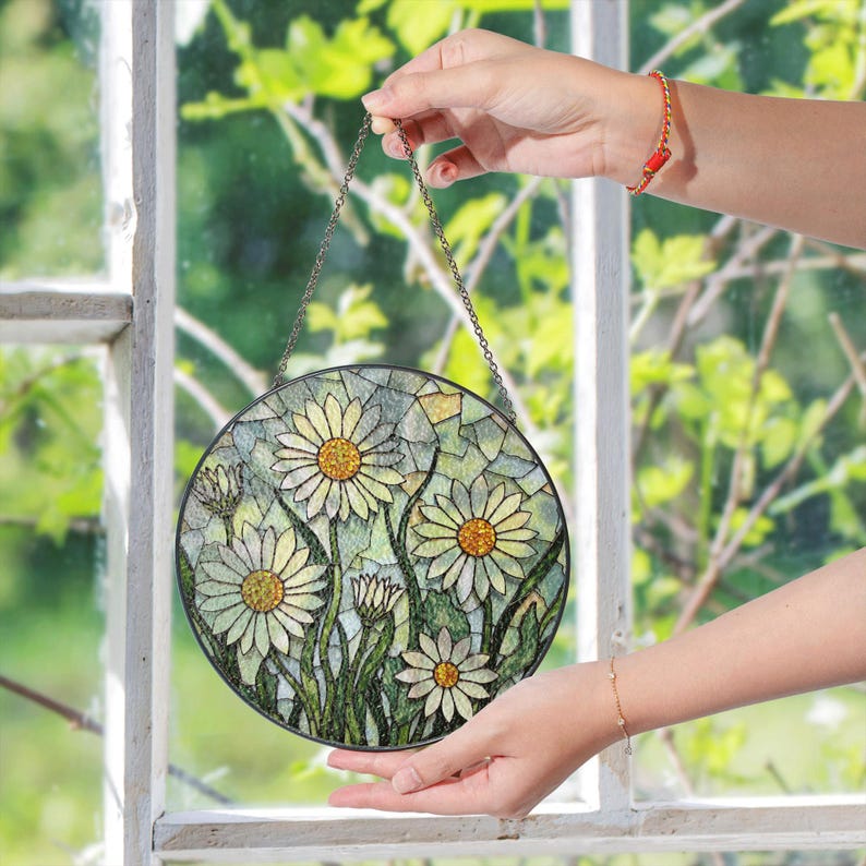 a hand holding a stained glass sun catcher