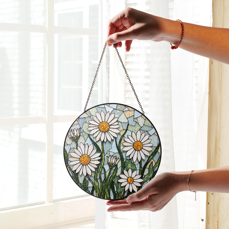 a hand holding a stained glass sun catcher