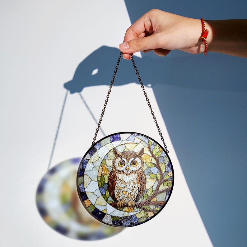 a stained glass owl hanging from a chain