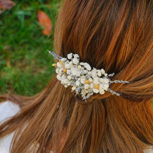 May include: A white and purple dried flower hair comb with small white flowers and lavender sprigs.