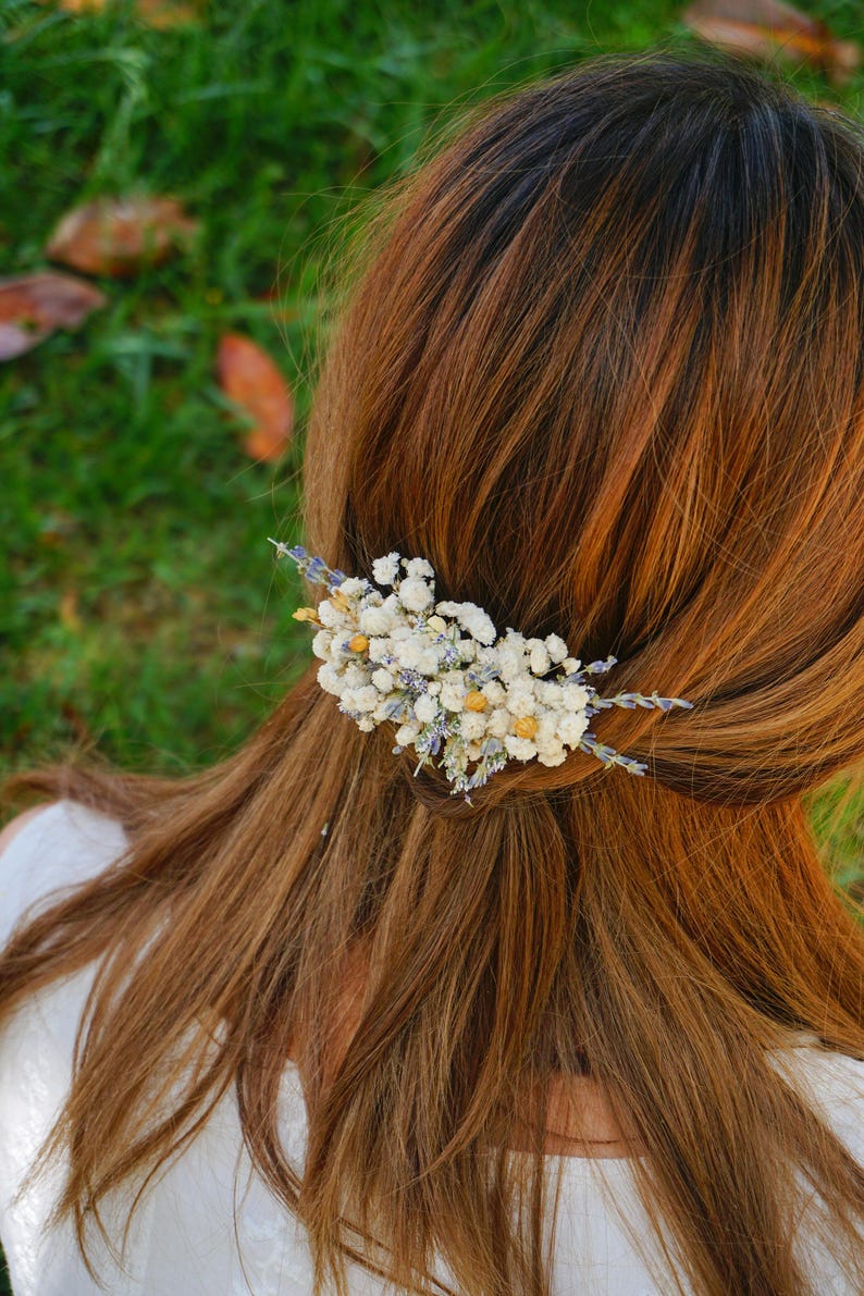 May include: A white and purple dried flower hair comb with small white flowers and lavender sprigs.