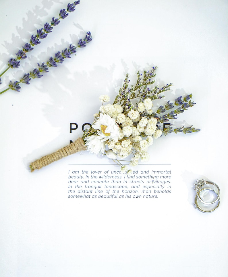 May include: A small bouquet of dried white and lavender flowers tied with twine. The bouquet is on a white surface with a quote about the beauty of nature.