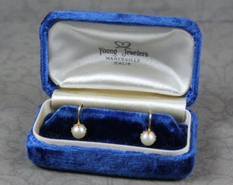 Pendientes vintage BDA de oro amarillo de 10 quilates con cierre de rosca y perla en caja de terciopelo azul.