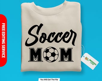 May include: A beige sweatshirt with a black graphic design that says "Soccer Mom" with a soccer ball in the middle of the word "Mom".