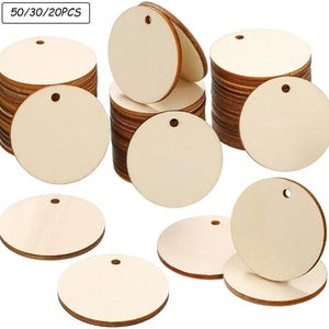 Op de afbeelding: Stapels ronde, onafgewerkte houten labels met voorgeboorde gaten. De labels zijn lichtbeige van kleur, met zichtbare houtnerf. De afbeelding bevat een label in de linkerbovenhoek met de tekst "50/30/20PCS".