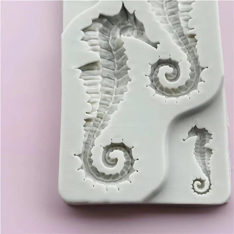 Pu&ograve; includere: Uno stampo in silicone bianco con tre disegni di cavallucci marini. I cavallucci marini hanno trame dettagliate e code arricciate. Lo stampo &egrave; rettangolare con angoli arrotondati, perfetto per creare oggetti artigianali o decorazioni a tema marino.