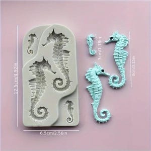 Pu&ograve; includere: Uno stampo in silicone grigio chiaro con forme di cavallucci marini, misura 12,5 cm x 6,5 cm, e tre figure di cavallucci marini blu chiaro staccate, una di 3 cm e due alte 8 cm. I cavallucci hanno trame dettagliate.