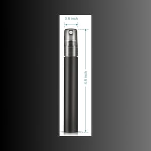 Puede incluir: Un atomizador de perfume cil&iacute;ndrico negro, de 11,7 cm de largo y 1,5 cm de ancho, con la parte superior plateada. El atomizador se muestra sobre un fondo degradado negro y gris.