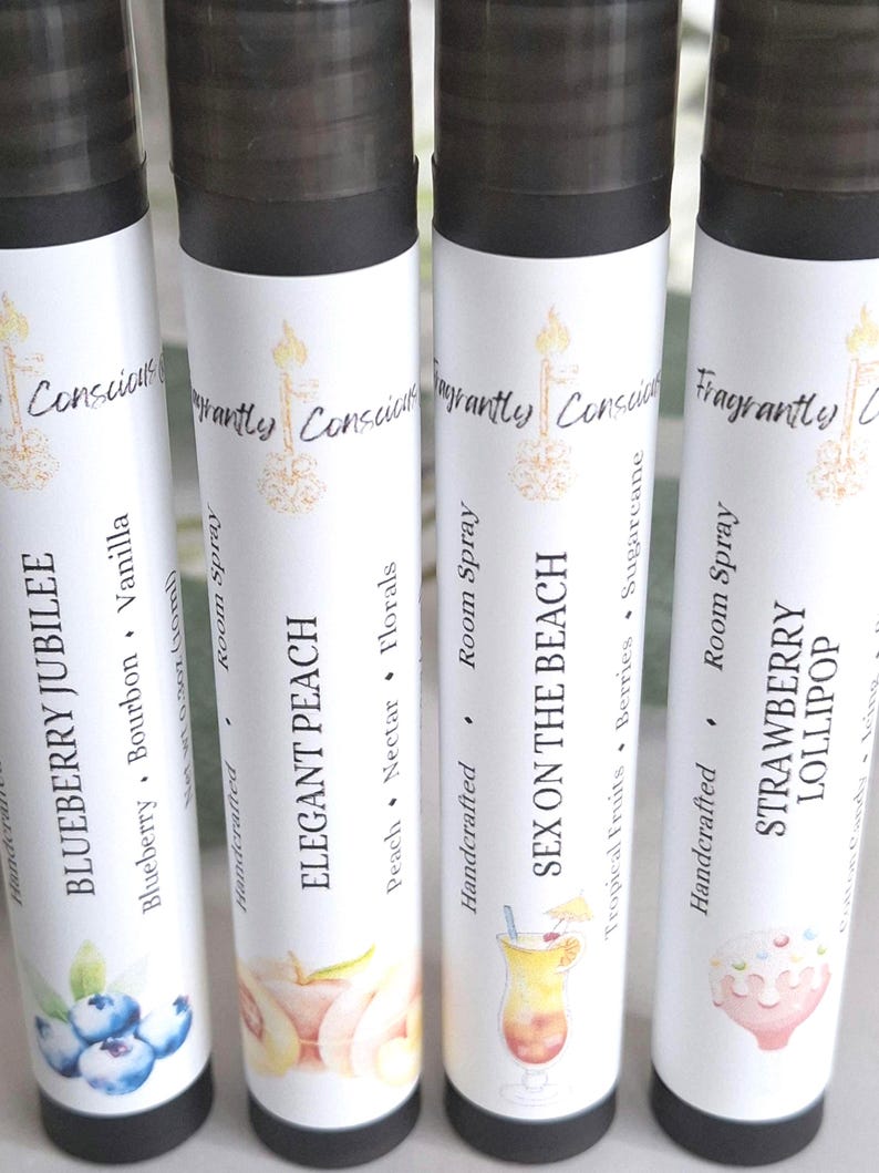 Puede incluir: Cuatro botellas de spray ambiental con tapas negras y etiquetas blancas. Las etiquetas presentan texto e ilustraciones para varios aromas: Blueberry Jubilee, Elegant Peach, Sex on the Beach y Strawberry Lollipop. Las botellas son artesanales.