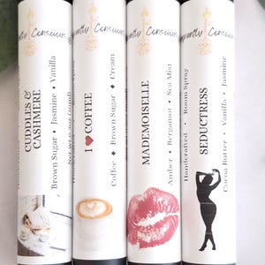 Puede incluir: Cuatro botellas cil&iacute;ndricas blancas con tapas negras. Las botellas presentan etiquetas con texto e ilustraciones, incluyendo "Cuddles & Cashmere", "I Coffee", "Mademoiselle" y "Seductress". Peso neto 10 ml.