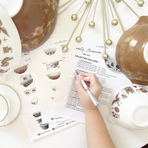 Peut inclure: Une liste de contrôle de bols mélangeurs et de bols Cinderella Pyrex vintage avec une main tenant un stylo au-dessus de la liste. La liste comprend la taille et la couleur de chaque bol. Le texte sur la liste indique "early American 1962-1971 Collection Includes: 2 pc Mixing Bowl Set, 4 pc Cinderella Bowl Set".