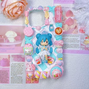 Peut inclure: Un étui de téléphone décoratif avec une figurine de style anime aux cheveux bleus, entourée de miniatures de bonbons, d'ustensiles et d'un carton de lait. L'étui est orné de couleurs pastel, dont le rose, le bleu et le blanc, créant une esthétique fantaisiste.