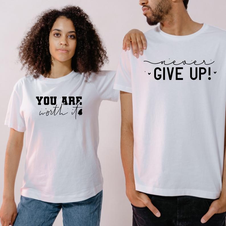 Pu&ograve; includere: Due magliette bianche con testo nero. Una maglietta dice "You are worth it" con un piccolo cuore. L'altra maglietta dice "never give up!" con un piccolo cuore.