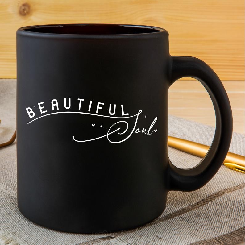 Pu&ograve; includere: Tazza in ceramica nera opaca con testo bianco che recita "Beautiful Soul" in un carattere corsivo.