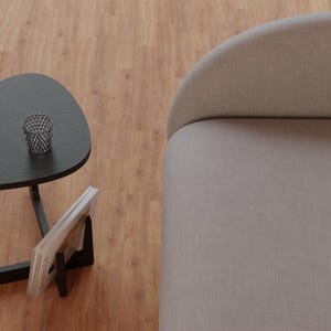 Peut inclure: Une table d'appoint triangulaire noire avec un porte-revues et un petit panier en fil de fer sur le dessus. La table est &agrave; c&ocirc;t&eacute; d'un canap&eacute; gris clair.