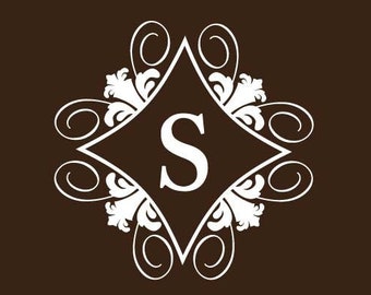 Könnte beinhalten: Weißes Wandtattoo mit dem Buchstaben "S" in einer Raute, umgeben von dekorativen floralen und geschwungenen Mustern. Das Tattoo ist an einer dunkelbraunen Wand angebracht. Der Raum umfasst eine Lampe, einen Nachttisch und einen weißen Stuhl.