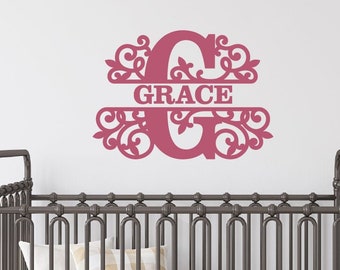 Könnte beinhalten: Ein dunkelrosa Wandtattoo mit dem Namen "GRACE" in einem dekorativen "G". Das Tattoo befindet sich über einem grauen Metall-Babybett mit weißer Matratze und Kissen. Ein hölzernes Schaukelpferd ist sichtbar.