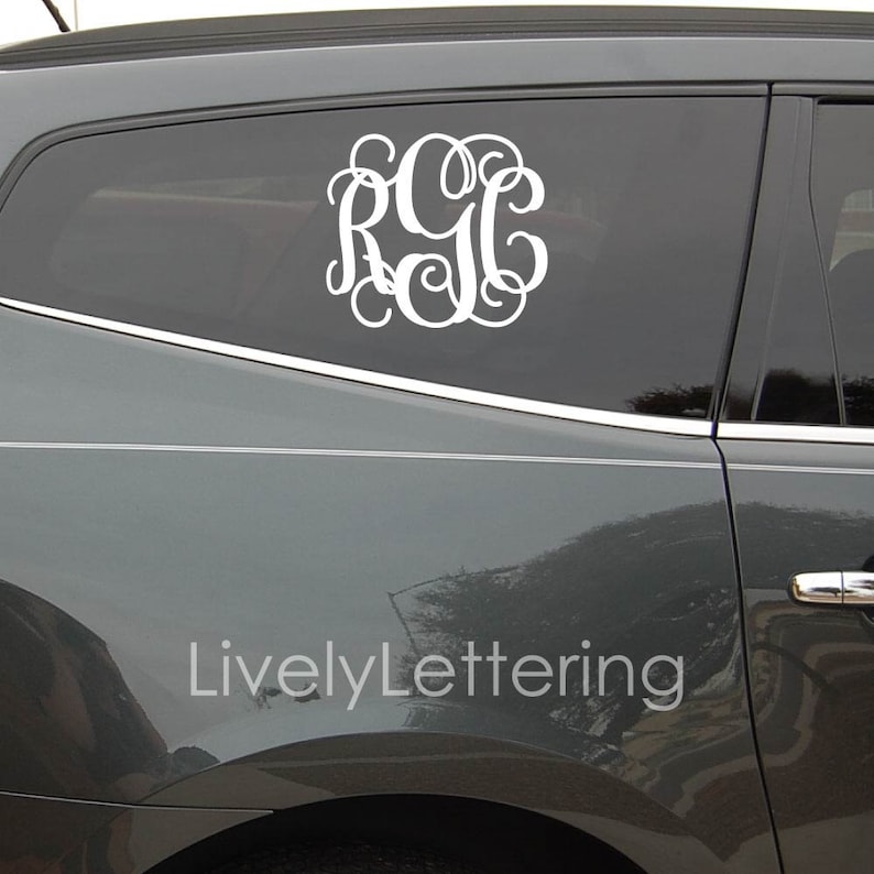 K&ouml;nnte beinhalten: Ein wei&szlig;er Monogramm-Aufkleber mit den Buchstaben RGC in einer dekorativen Schreibschrift auf einem grauen Auto. Der Aufkleber befindet sich an der Heckscheibe des Autos. Der Text "LivelyLettering" ist auf dem Auto sichtbar.