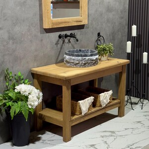 May include: A rustic wooden bathroom vanity with a stone sink and two woven baskets on the lower shelf. The vanity is made of reclaimed wood and has a natural finish.