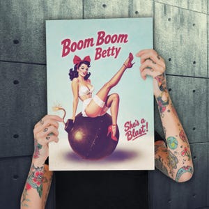 May include: A vintage-style poster featuring a pin-up girl sitting on a bomb. The poster has the text "Boom Boom Betty" in red script, with the phrase "She's a Blast!" below the image. The woman is wearing white lingerie and red heels.