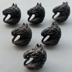 May include: Six antique-style drawer pulls shaped like horse heads. The dark metal pulls feature detailed manes and facial features. Each pull is approximately 5 cm in height. Ideal for adding a vintage touch to furniture.