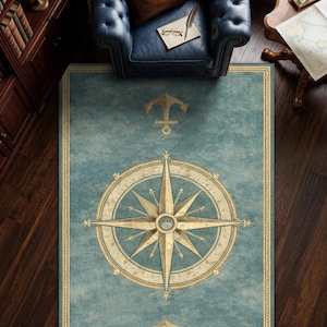 Peut inclure: Un tapis rectangulaire sur le thème nautique. Le tapis présente une rose des vents dorée et crème sur fond bleu-vert, avec des ancres dorées en haut et en bas. La bordure est un motif de corde dorée. Le tapis est posé sur un sol en bois foncé.