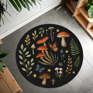May include: A circular black rug with a whimsical design of mushrooms, butterflies, and foliage in shades of orange, brown, green, and blue. The rug has a diameter of approximately 122 cm, suitable for a living room or bedroom.