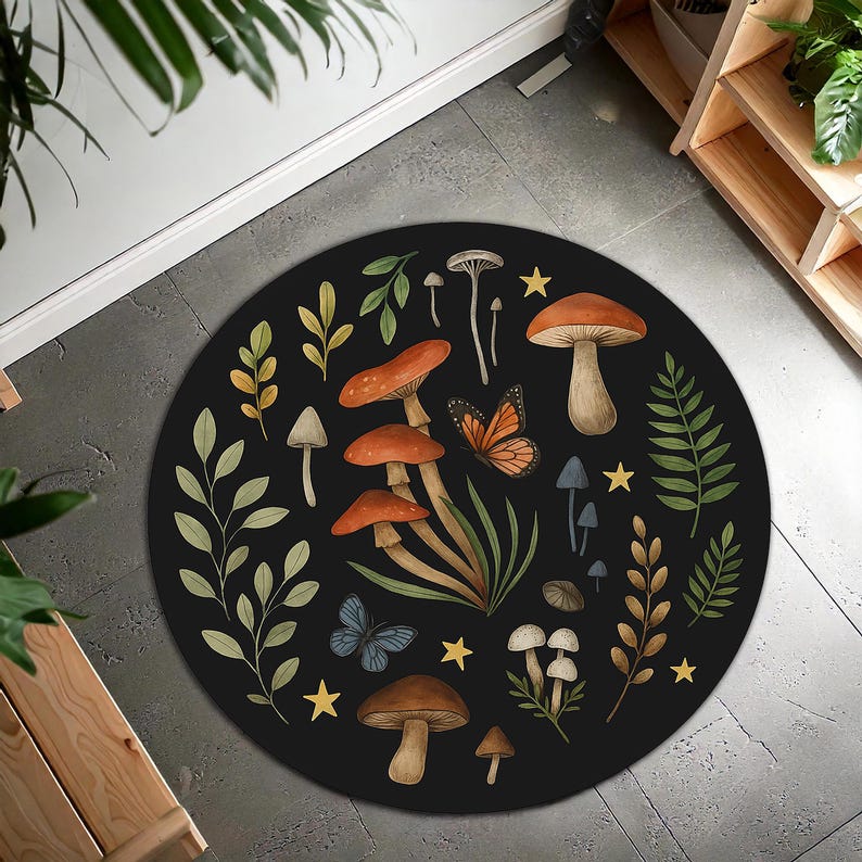 May include: A circular black rug with a whimsical design of mushrooms, butterflies, and foliage in shades of orange, brown, green, and blue. The rug has a diameter of approximately 122 cm, suitable for a living room or bedroom.