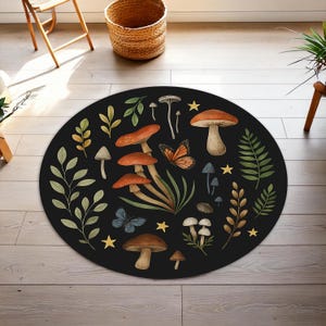 May include: A circular black rug with a mushroom and butterfly pattern. The rug features illustrations of various mushrooms in brown and orange, along with butterflies, stars, and leaves. A decorative floor covering.