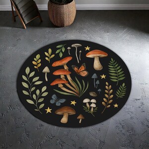 May include: A circular black rug with a whimsical mushroom and butterfly design. The rug features illustrations of mushrooms in brown, orange, and white, alongside green foliage, butterflies, and yellow stars. The rug's diameter is approximately 120 cm.