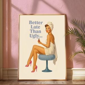 May include: Framed vintage-style print featuring a woman in a towel, seated on a blue stool, holding nail polish. The print includes the text "Better Late Than Ugly..." in blue letters. The woman wears pink high heels.