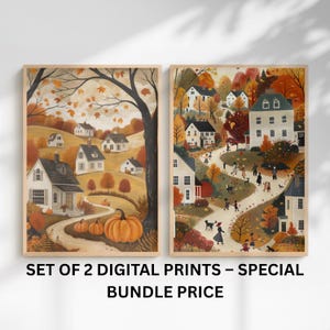 May include: Set of two framed digital prints depicting autumn scenes. One print features a village with pumpkins, the other shows a village with people walking on a path. The prints have a warm color palette of orange, brown, and white.