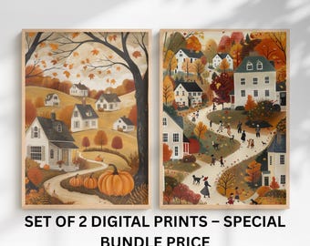 May include: Set of two framed digital prints depicting autumn scenes. One print features a village with pumpkins, the other shows a village with people walking on a path. The prints have a warm color palette of orange, brown, and white.