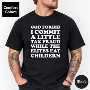 Könnte beinhalten: Ein schwarzes Kurzarm-T-Shirt mit weißem Textaufdruck: GOD FORBID I COMMIT A LITTLE TAX FRAUD WHILE THE ELITES EAT CHILDERN. Das Shirt hat einen Rundhalsausschnitt und eine normale Passform, inklusive eines sichtbaren Comfort Colors Etiketts.