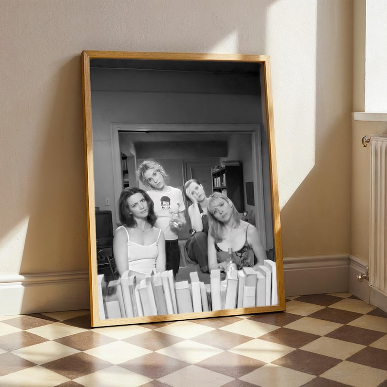 a framed black and white photograph of four people posing together in a room with a checkered floor.