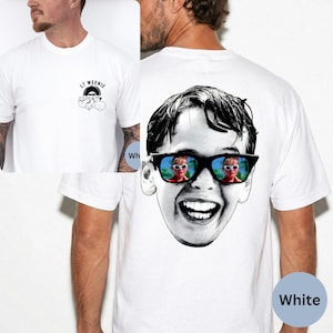 May include: White t-shirt featuring a black and white graphic of a smiling face wearing sunglasses with a mirrored reflection. The front of the shirt has a small graphic with the text "LT WEENIE" and a rainbow design.