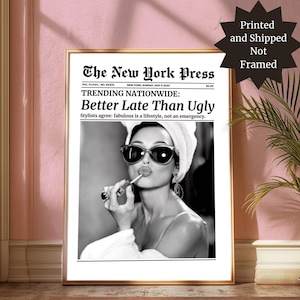 May include: A framed black and white print, styled as a vintage newspaper front page, with a woman applying lipstick. The headline reads "Better Late Than Ugly." The print is in a gold frame, with text that says "Printed and Shipped Not Framed."