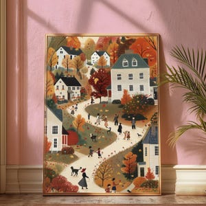 May include: A framed art print depicting a charming autumn scene. The artwork showcases a winding path through a village, with houses and trees in fall colors. Figures stroll along the path, some with dogs, creating a warm, inviting atmosphere.