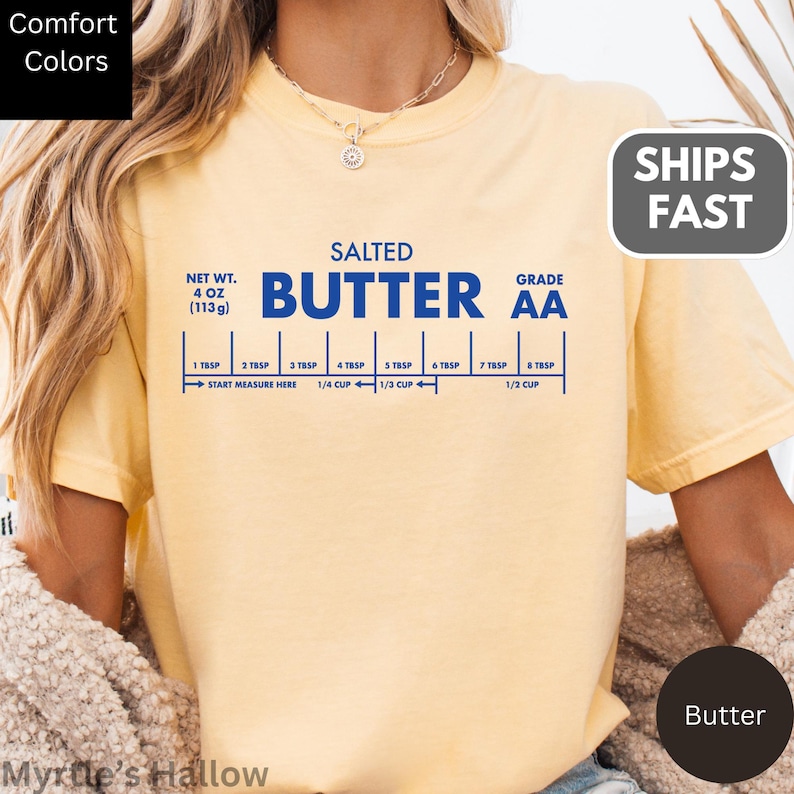 A person wearing a yellow t-shirt with a graphic design depicting the nutritional information and measurements of a bag of salted butter.