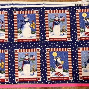 May include: A blue fabric with a white background and a repeating pattern of snowmen wearing red, white and blue hats and holding American flags. The snowmen are surrounded by stars and stripes. The text "Oh Say... Can You See?", "Let Freedom Ring", "Stars and Stripes Forever", and "Liberty and Justice for All" is repeated throughout the fabric.