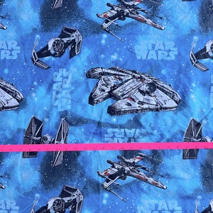 May include: Blue fabric with a repeating pattern of Star Wars spaceships and the text "Star Wars".