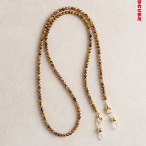 Op de afbeelding: Brillenketting gemaakt van kleine, ronde tijgeroog kralen in bruin- en goudtinten. De ketting heeft goudkleurige sluitingen en doorzichtige rubberen lussen om aan brillen te bevestigen. De tekst "404REDCUBE" staat rechtsboven.
