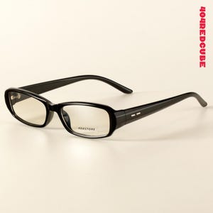 May include: Black rectangular spectacles with a glossy finish. The lenses are clear and feature the text 404STORE printed on the right lens. The temples have two small silver-coloured rectangular accents near the hinges. 404REDCUBE is printed vertically.