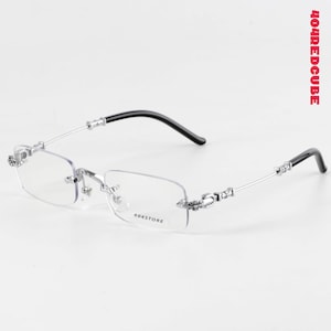 Puede incluir: Gafas sin montura con montura de metal plateado y patillas negras. Las lentes rectangulares son transparentes y las monturas presentan detalles florales decorativos. El texto "404STORE" está impreso en la lente.