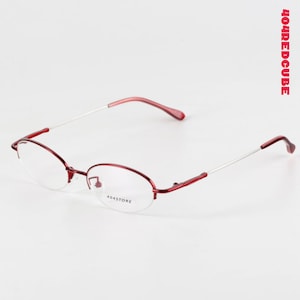 May include: Oval-shaped eyeglasses in red and silver, with the text "404STORE" on the lens. The frames are a deep red, with silver arms and red temple tips. The text "404REDCUBE" is printed vertically in red on the right side.