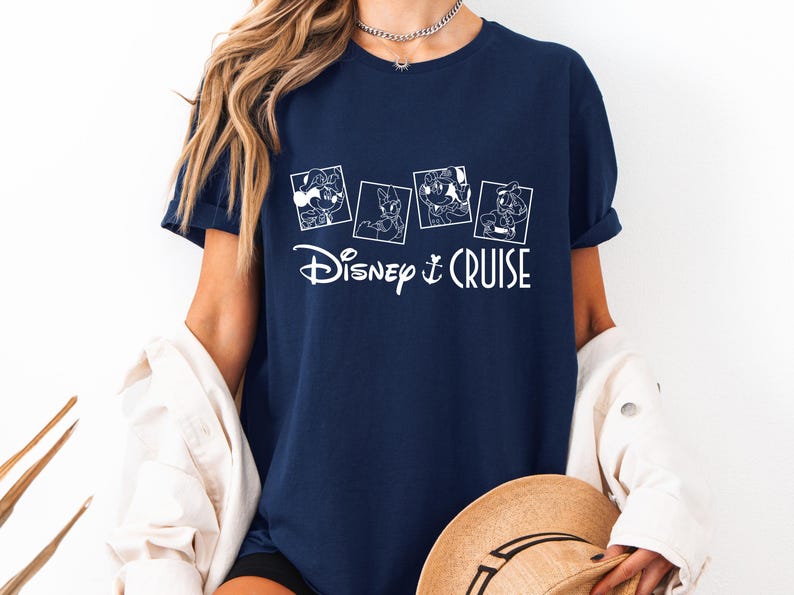 May include: A navy blue t-shirt with a white graphic of four Disney characters in squares and the text "Disney Cruise".
