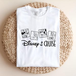 May include: White t-shirt with a black and white graphic of Mickey Mouse, Minnie Mouse, Donald Duck, and Goofy in a photo booth. The text "Disney Cruise" is below the photos.